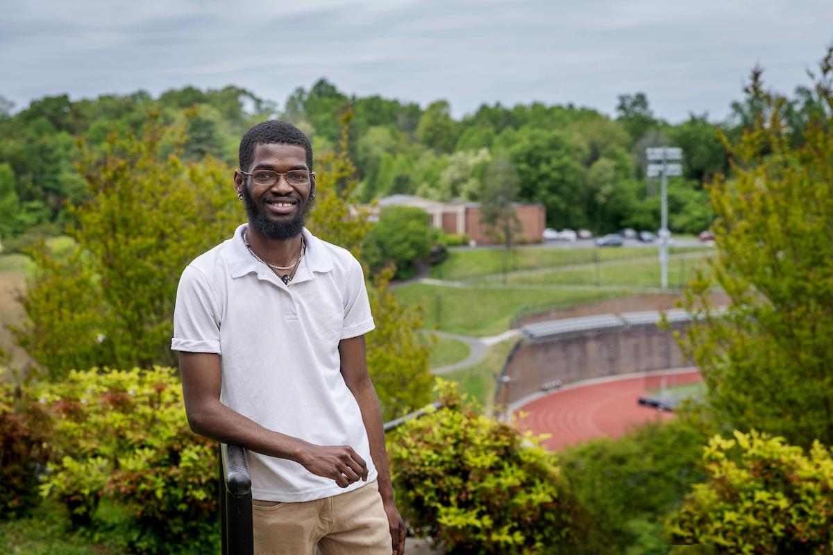 Tristian Palmer '24 poses with the track in the background 